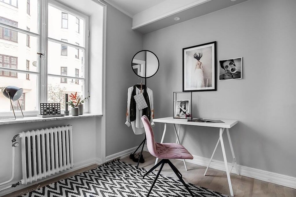 Inspiration for a medium sized scandi home office in Stockholm with grey walls, light hardwood flooring and a freestanding desk.