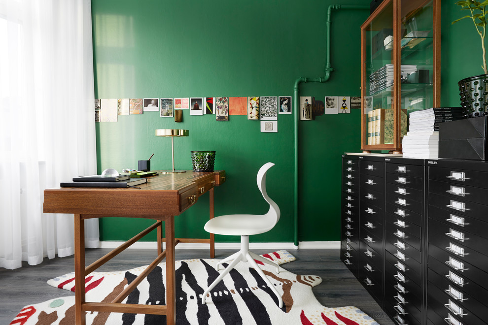 Пример оригинального дизайна: рабочее место среднего размера в стиле фьюжн с зелеными стенами, паркетным полом среднего тона и отдельно стоящим рабочим столом