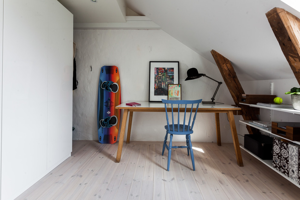 Small bohemian home office in Stockholm with white walls, a freestanding desk and beige floors.