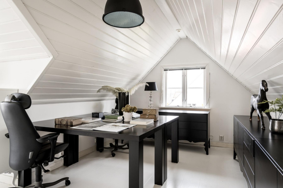 На фото: кабинет в скандинавском стиле с белыми стенами, деревянным полом, отдельно стоящим рабочим столом, белым полом, потолком из вагонки и сводчатым потолком