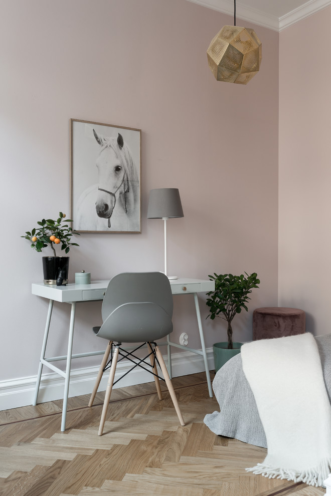 ストックホルムにある小さな北欧スタイルのおしゃれなホームオフィス・書斎 (ピンクの壁、淡色無垢フローリング、自立型机、ベージュの床) の写真