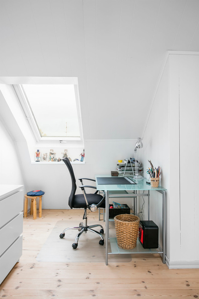 Foto på ett skandinaviskt arbetsrum, med vita väggar, mellanmörkt trägolv och beiget golv