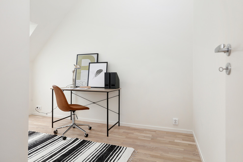 Idee per uno studio nordico con pareti bianche, pavimento in legno massello medio e scrivania autoportante