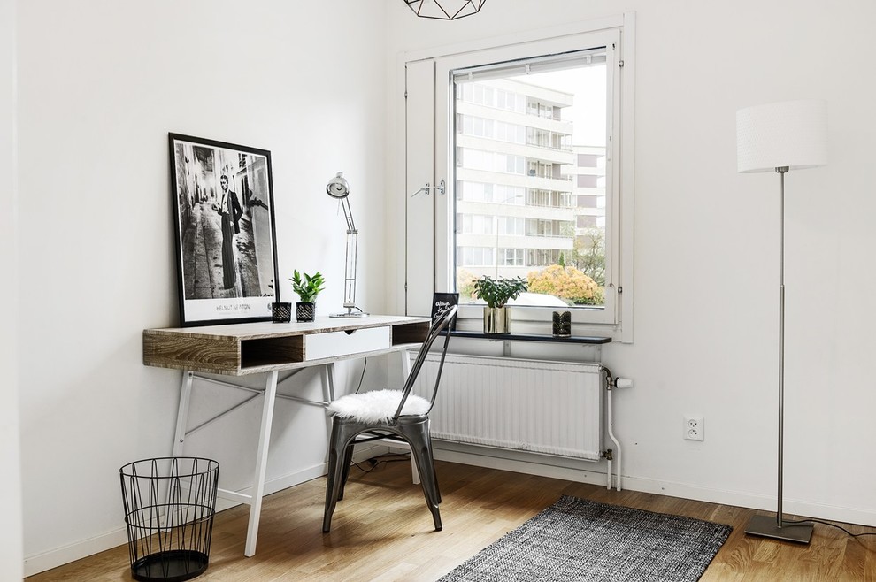 Свежая идея для дизайна: рабочее место в скандинавском стиле с белыми стенами, паркетным полом среднего тона и отдельно стоящим рабочим столом - отличное фото интерьера