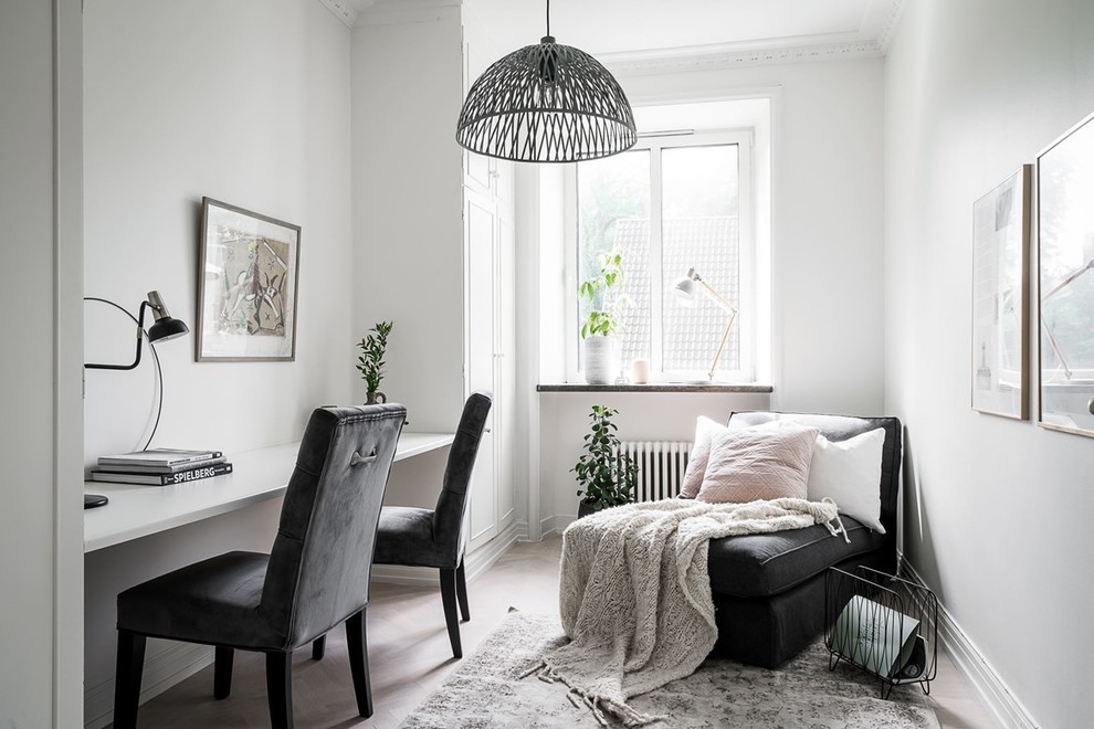 Inspiration for a scandi home office in Gothenburg with white walls, light hardwood flooring, a built-in desk and beige floors.