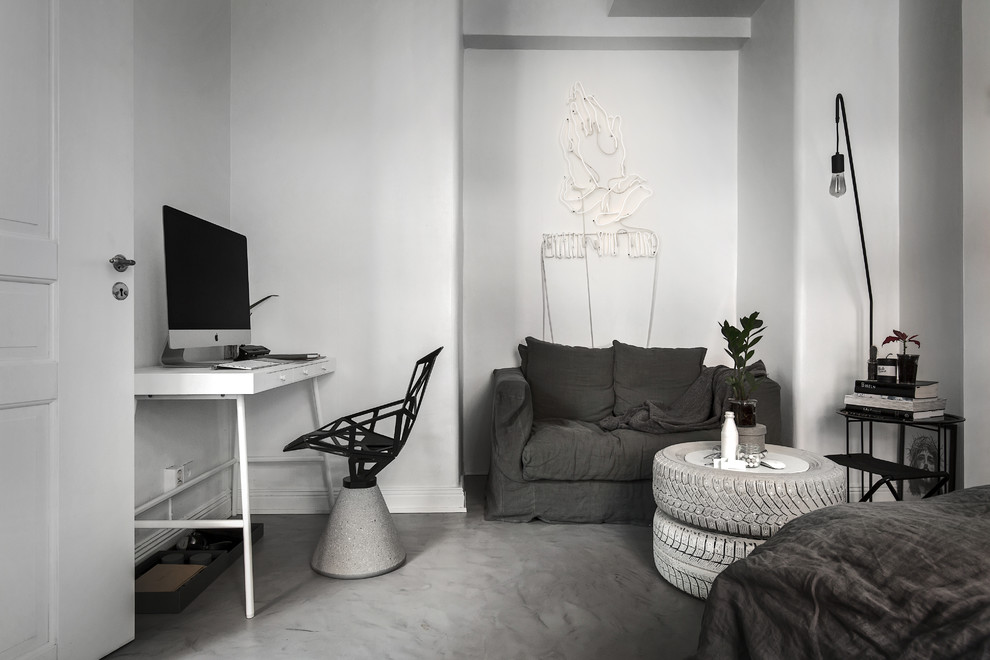 Medium sized scandi study in Stockholm with white walls, a freestanding desk and concrete flooring.