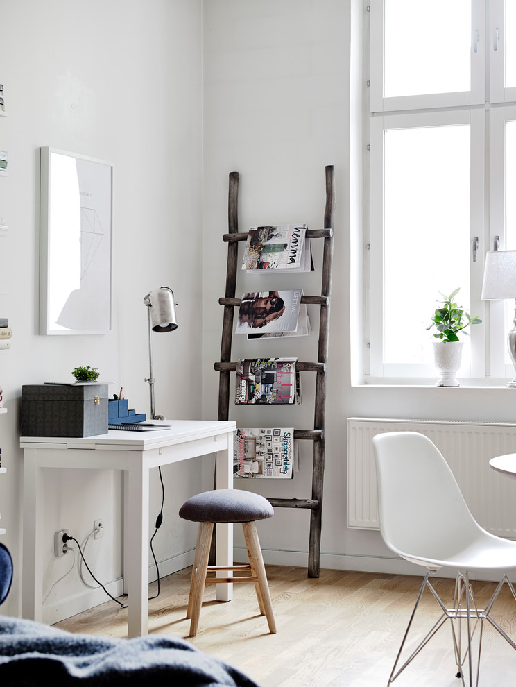 Design ideas for a medium sized scandinavian study in Gothenburg with white walls, light hardwood flooring, a freestanding desk and no fireplace.
