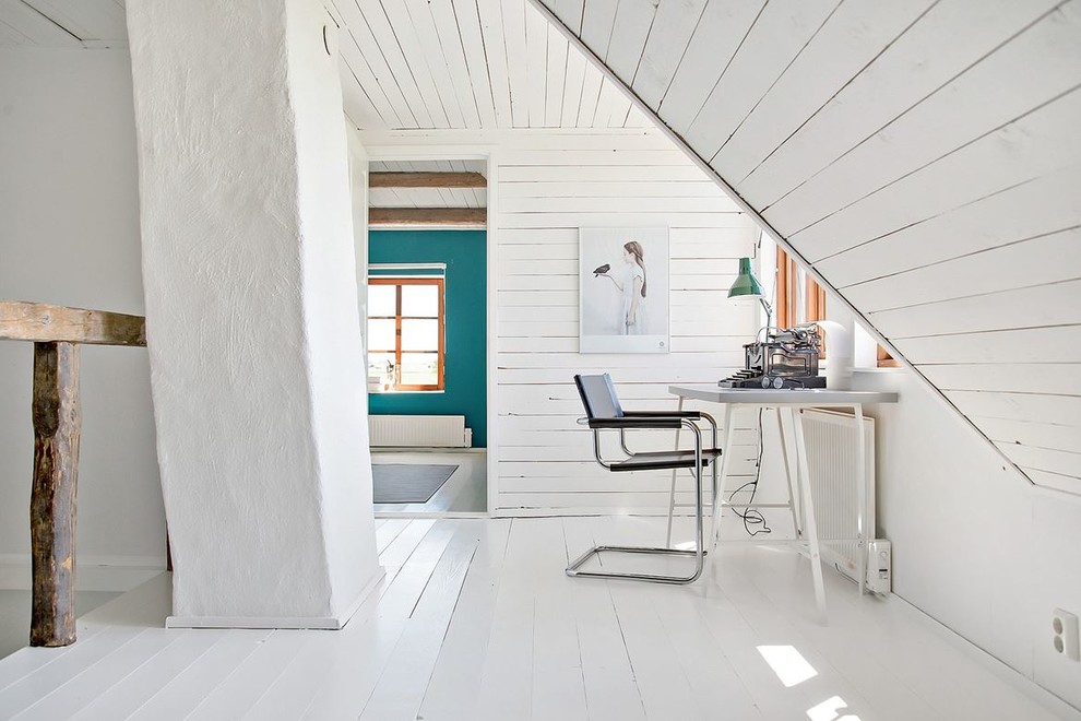 На фото: кабинет среднего размера в скандинавском стиле с белыми стенами, деревянным полом, отдельно стоящим рабочим столом и белым полом с