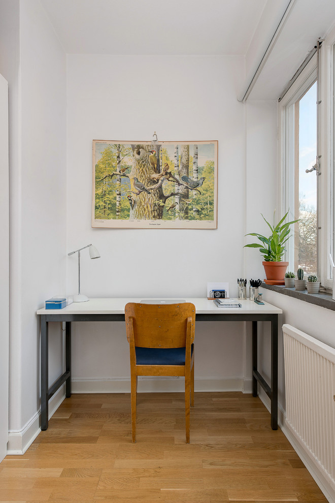 Inspiration för små 60 tals arbetsrum, med vita väggar, mellanmörkt trägolv, ett fristående skrivbord och brunt golv