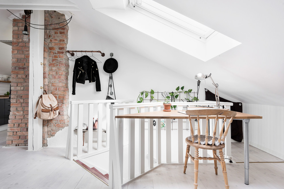 ヨーテボリにある小さな北欧スタイルのおしゃれなホームオフィス・書斎 (白い壁、淡色無垢フローリング、自立型机) の写真
