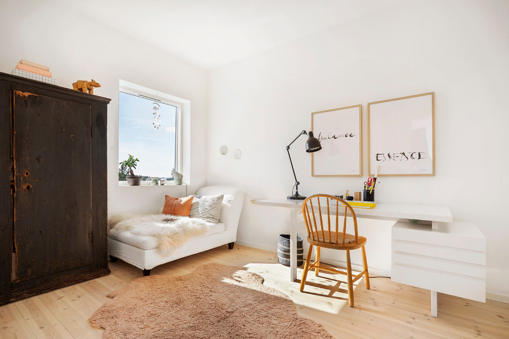Foto de despacho escandinavo de tamaño medio sin chimenea con paredes blancas, suelo de madera clara y escritorio independiente