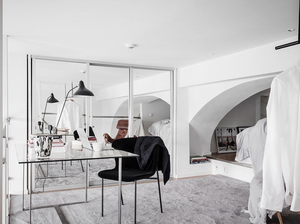 Пример оригинального дизайна: кабинет в скандинавском стиле с белыми стенами и отдельно стоящим рабочим столом без камина