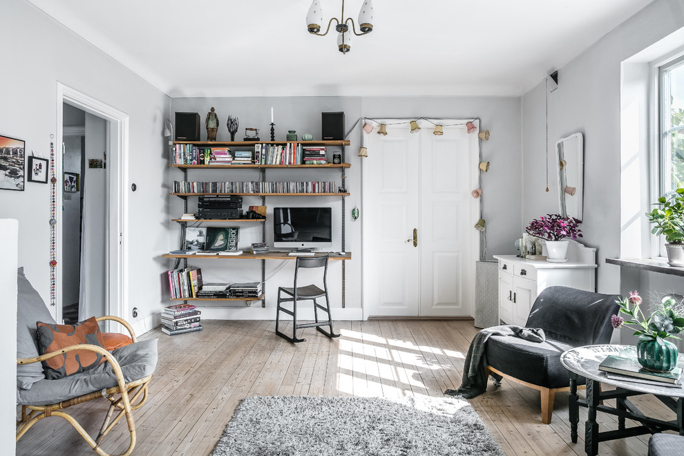 Medium sized scandi home office in Stockholm with grey walls, light hardwood flooring, no fireplace and beige floors.