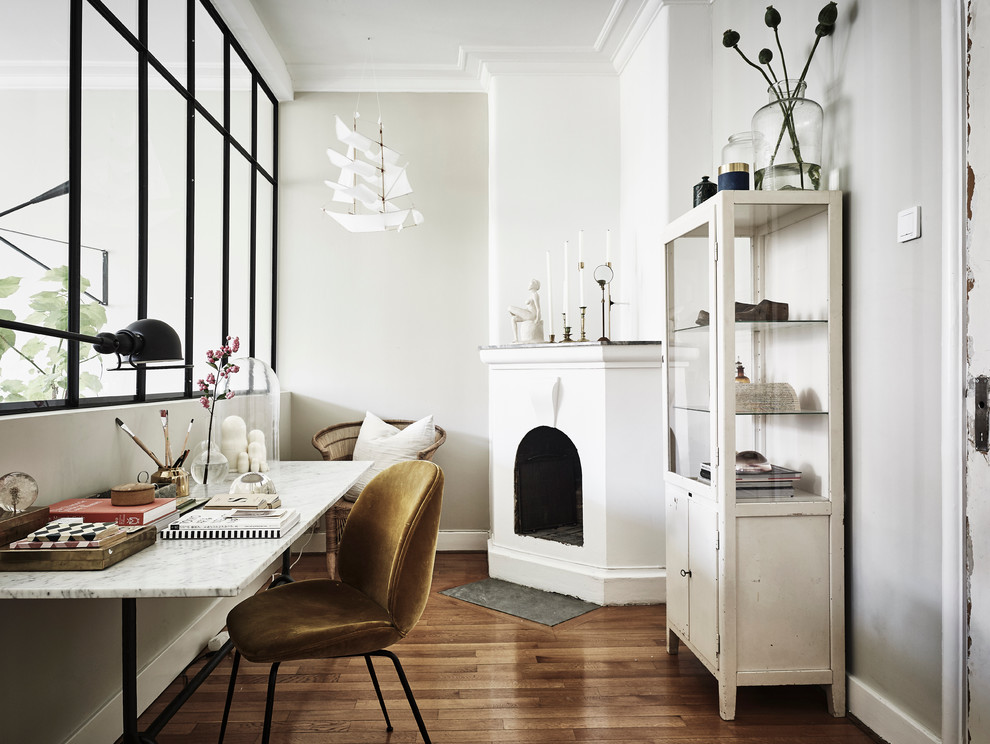 Mittelgroßes Nordisches Nähzimmer mit weißer Wandfarbe, braunem Holzboden und freistehendem Schreibtisch in Göteborg