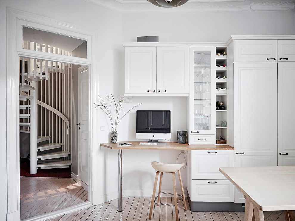 Inspiration för små nordiska arbetsrum, med vita väggar, ljust trägolv, ett inbyggt skrivbord och beiget golv