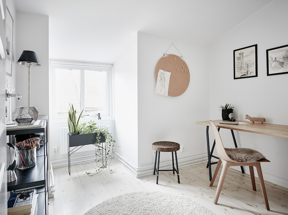 Foto de despacho nórdico de tamaño medio con paredes blancas, suelo de madera clara y escritorio independiente