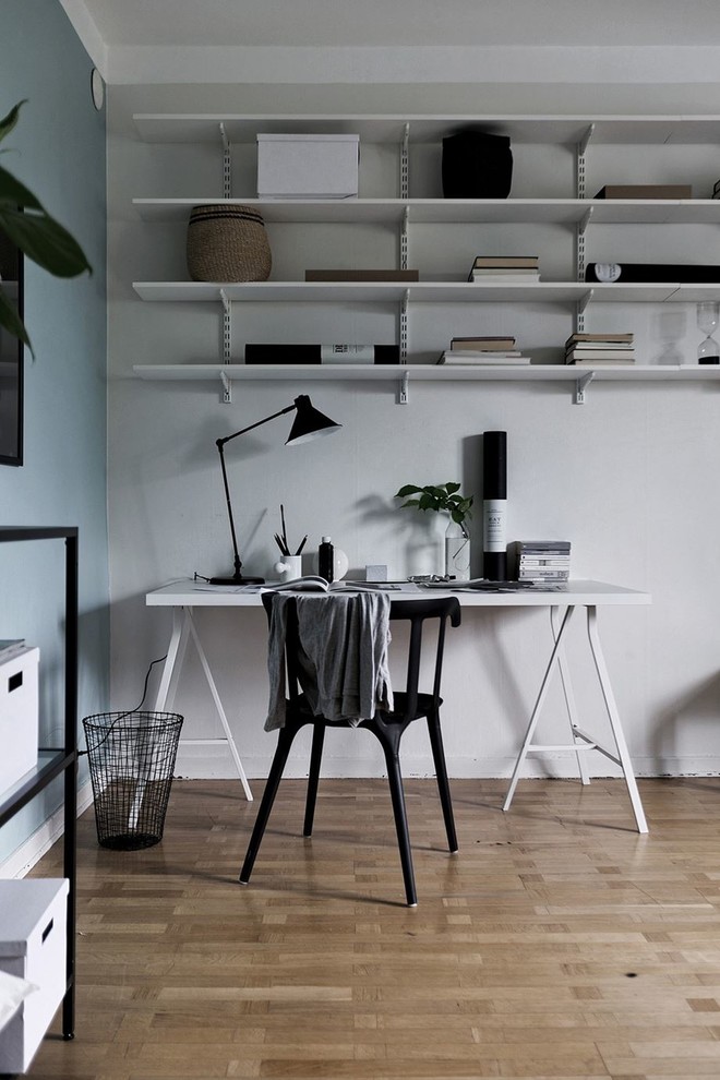Aménagement d'un bureau scandinave de taille moyenne avec un mur multicolore, un sol en bois brun, un bureau indépendant et un sol marron.