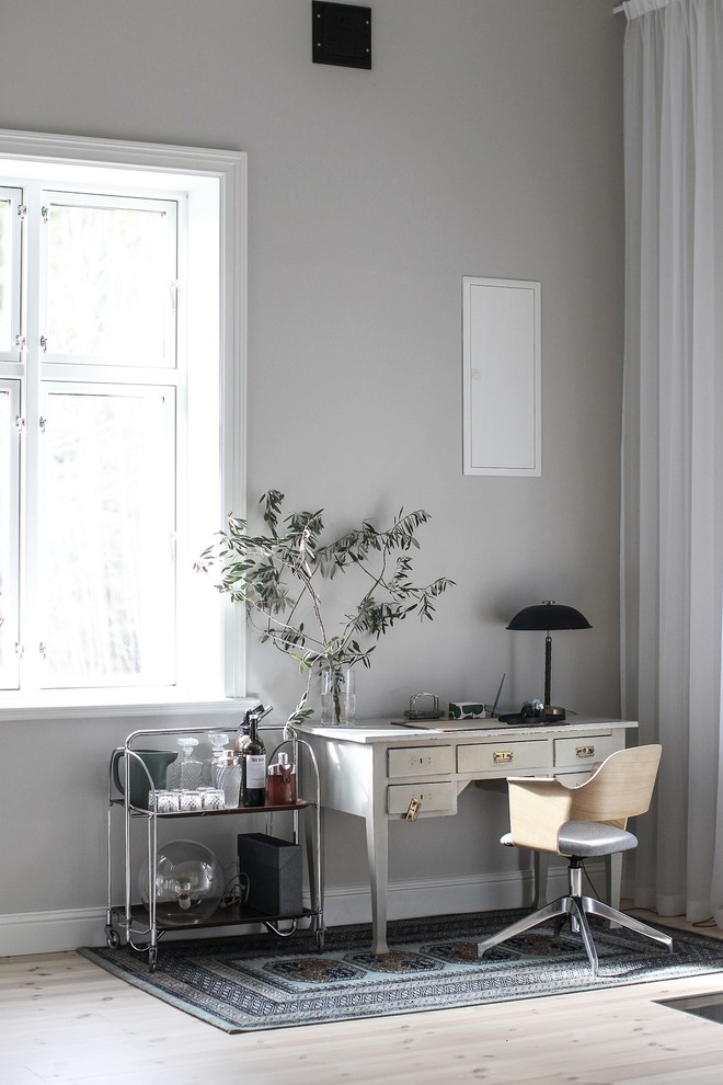 Immagine di uno studio scandinavo con pareti grigie e parquet chiaro