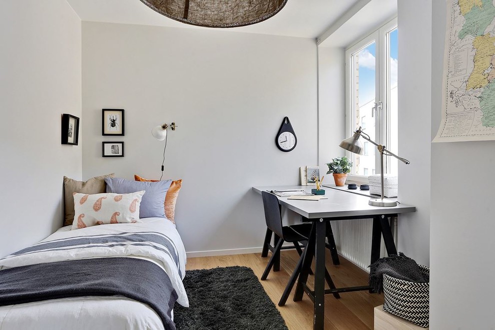 Imagen de despacho nórdico pequeño con escritorio independiente, paredes blancas, suelo de madera en tonos medios y suelo marrón