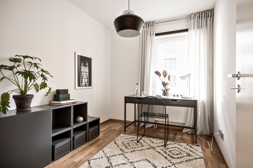 Exemple d'un bureau scandinave avec un mur blanc, un sol en bois brun, un bureau indépendant et un sol marron.