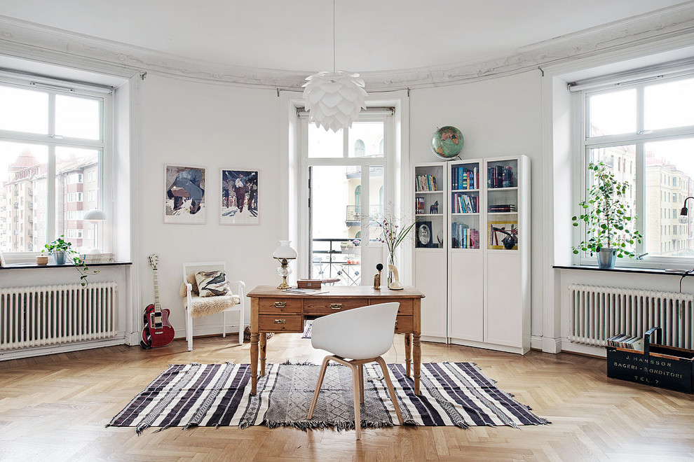 Imagen de despacho tradicional renovado grande sin chimenea con paredes blancas, suelo de madera clara y escritorio independiente