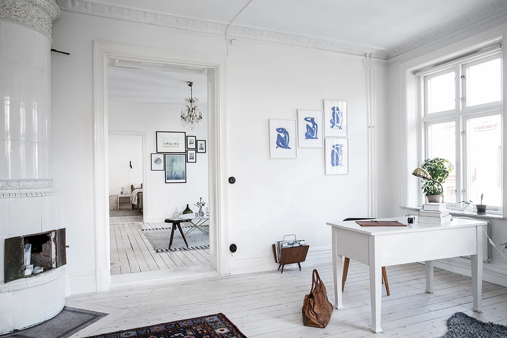 Mittelgroßes Klassisches Arbeitszimmer ohne Kamin mit Arbeitsplatz, weißer Wandfarbe, hellem Holzboden und freistehendem Schreibtisch in Göteborg