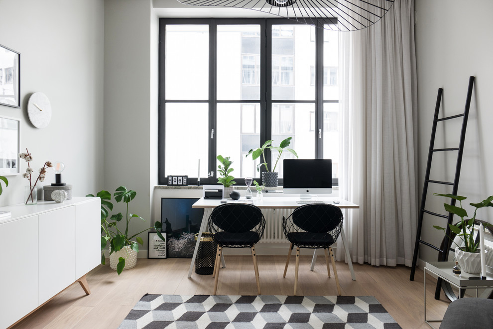 Inspiration för mellanstora nordiska arbetsrum, med vita väggar, ljust trägolv och ett fristående skrivbord