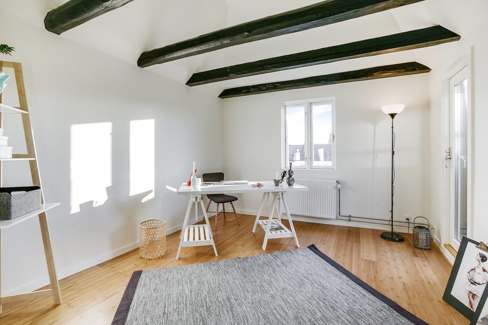 Mittelgroßes Nordisches Arbeitszimmer ohne Kamin mit weißer Wandfarbe, hellem Holzboden und freistehendem Schreibtisch in Sonstige
