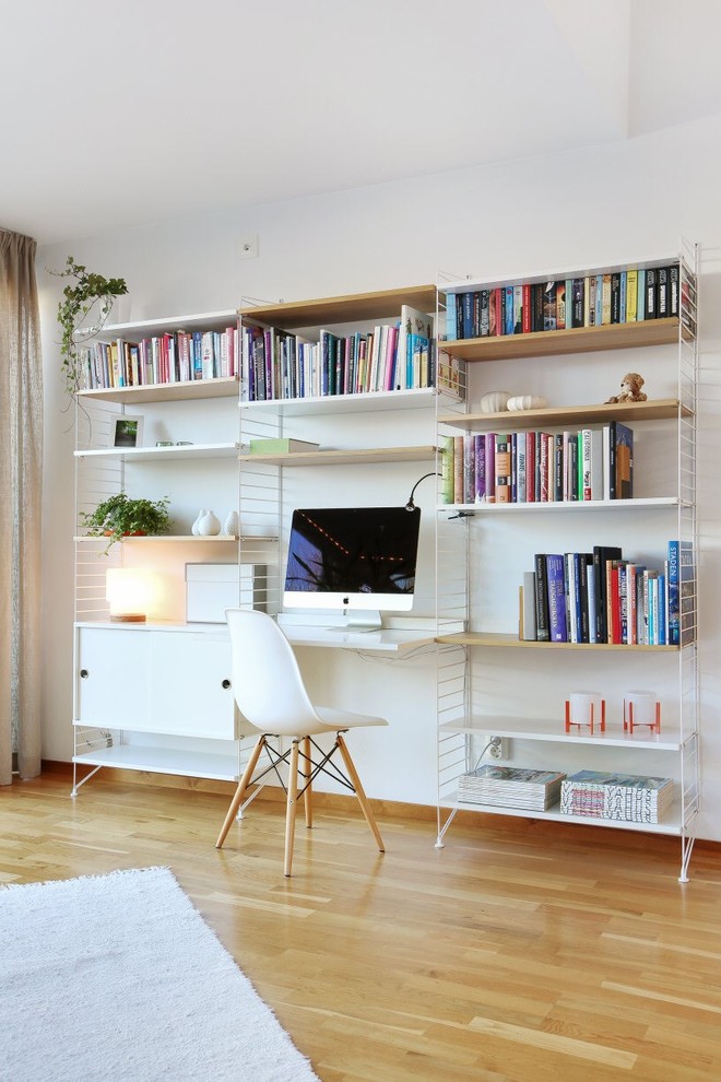Immagine di un ufficio nordico con pareti bianche, parquet chiaro, nessun camino e scrivania incassata