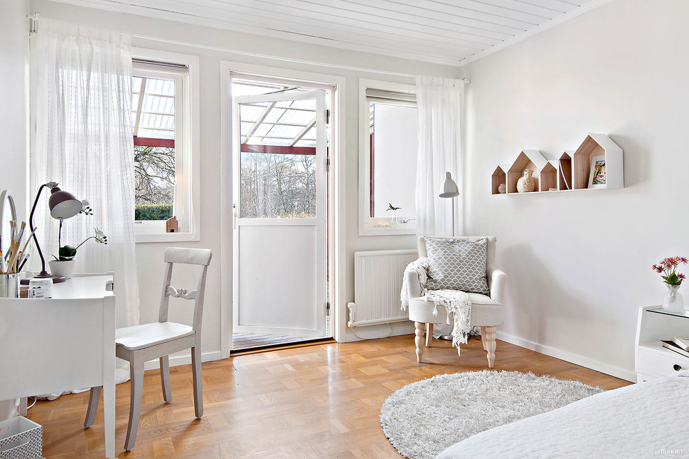 Inspiration for a medium sized scandi craft room in Gothenburg with white walls, light hardwood flooring and a freestanding desk.