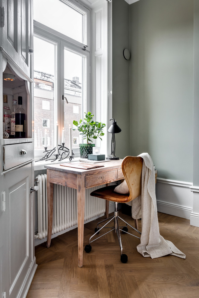 Cette photo montre un petit bureau victorien avec un mur vert, un sol en bois brun, aucune cheminée et un bureau indépendant.