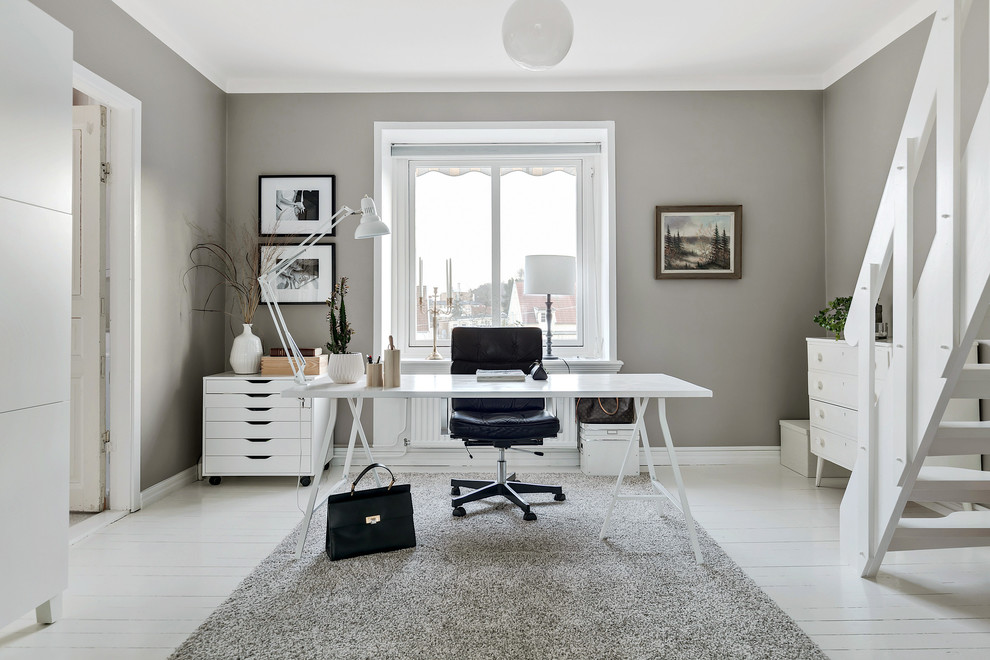 Foto di uno studio nordico di medie dimensioni con pareti grigie, pavimento in legno verniciato, scrivania autoportante e pavimento bianco