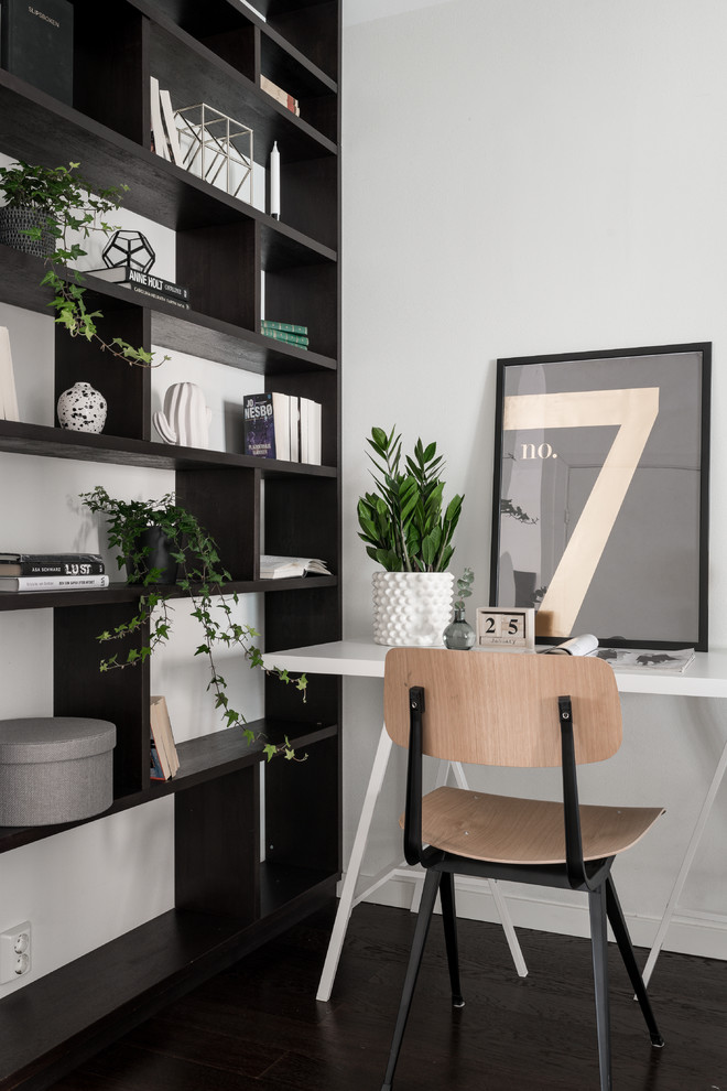 Imagen de despacho nórdico con paredes blancas, suelo de madera oscura, escritorio independiente y suelo negro