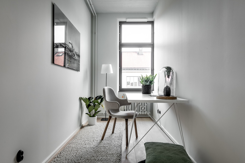 Idéer för ett litet modernt arbetsrum, med vita väggar, ljust trägolv och ett fristående skrivbord