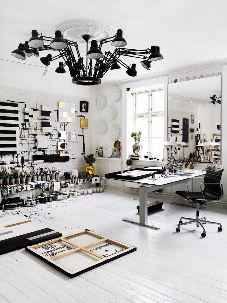 Großes Eklektisches Arbeitszimmer ohne Kamin mit Studio, weißer Wandfarbe, gebeiztem Holzboden, freistehendem Schreibtisch und weißem Boden in Stockholm
