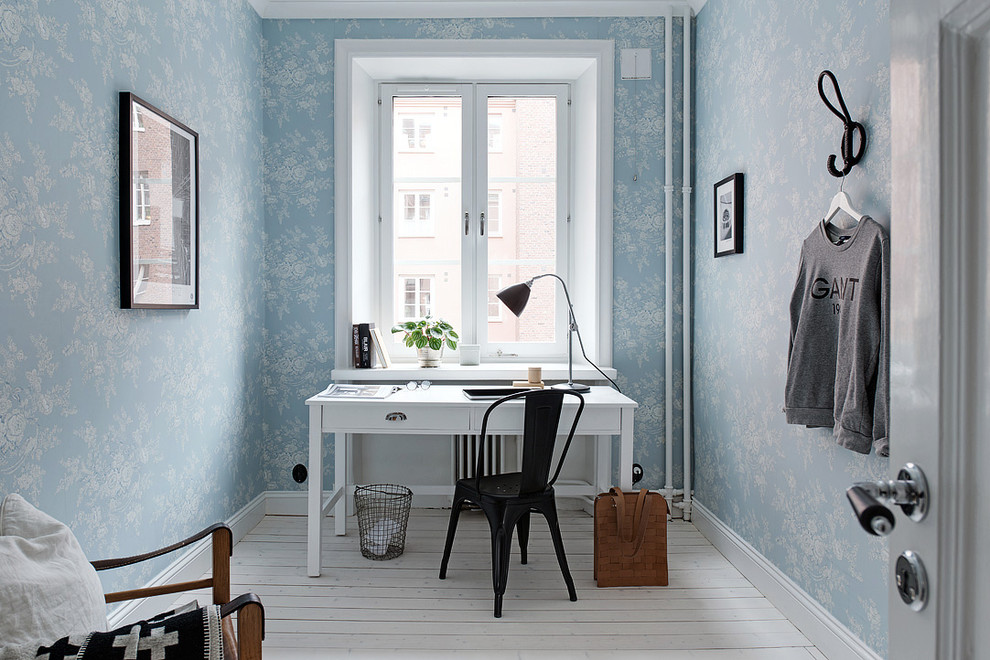 Ejemplo de despacho tradicional de tamaño medio sin chimenea con paredes azules, suelo de madera pintada y escritorio independiente