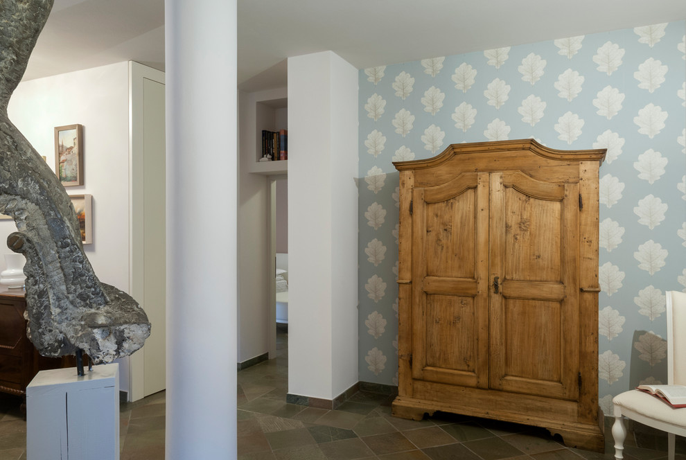 Imagen de salón cerrado actual de tamaño medio con paredes blancas, suelo de pizarra, suelo gris y papel pintado