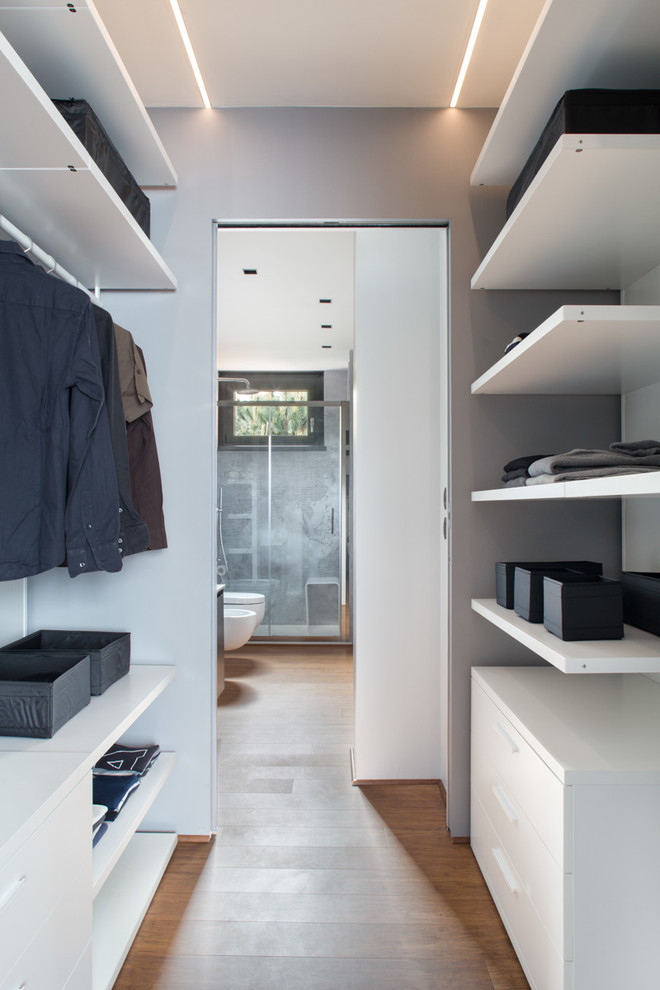 Стильный дизайн: гардеробная комната в современном стиле с открытыми фасадами, белыми фасадами и паркетным полом среднего тона для мужчин - последний тренд