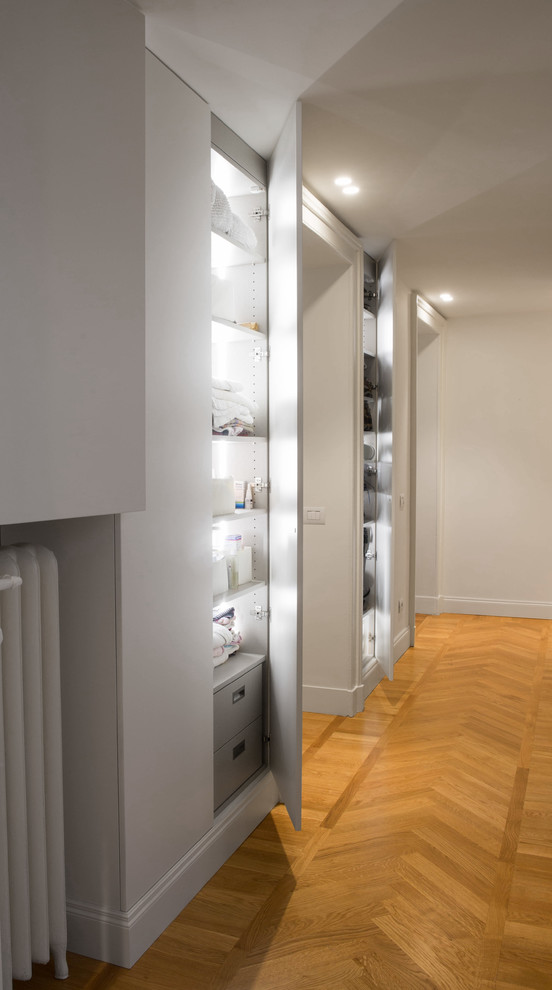 Idee per un piccolo armadio o armadio a muro unisex design con ante lisce, ante bianche e pavimento in legno massello medio