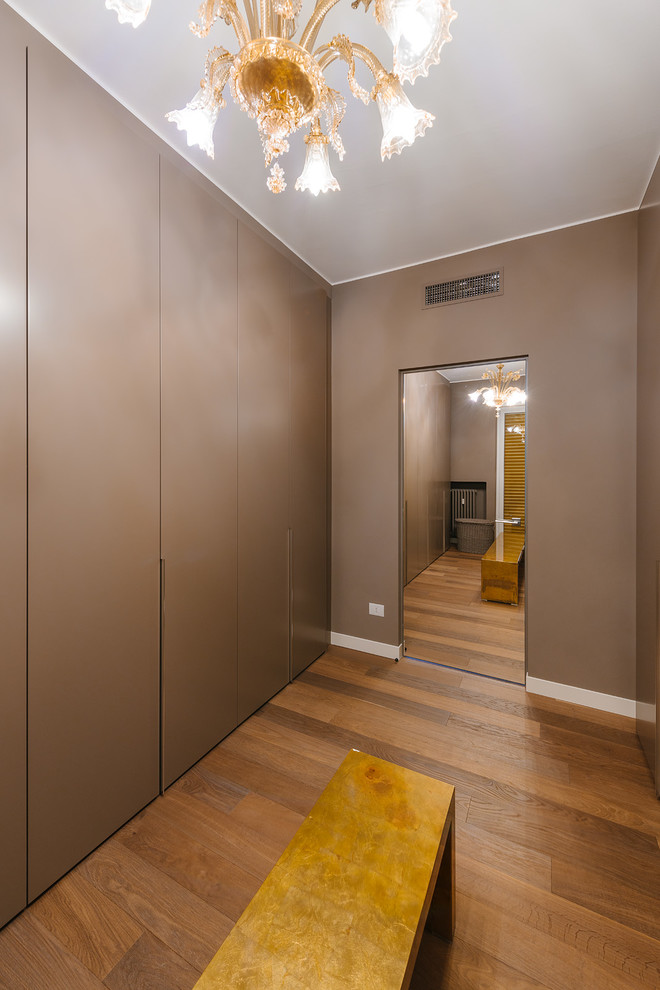 ミラノにある広いコンテンポラリースタイルのおしゃれなフィッティングルーム (フラットパネル扉のキャビネット、茶色いキャビネット、無垢フローリング) の写真