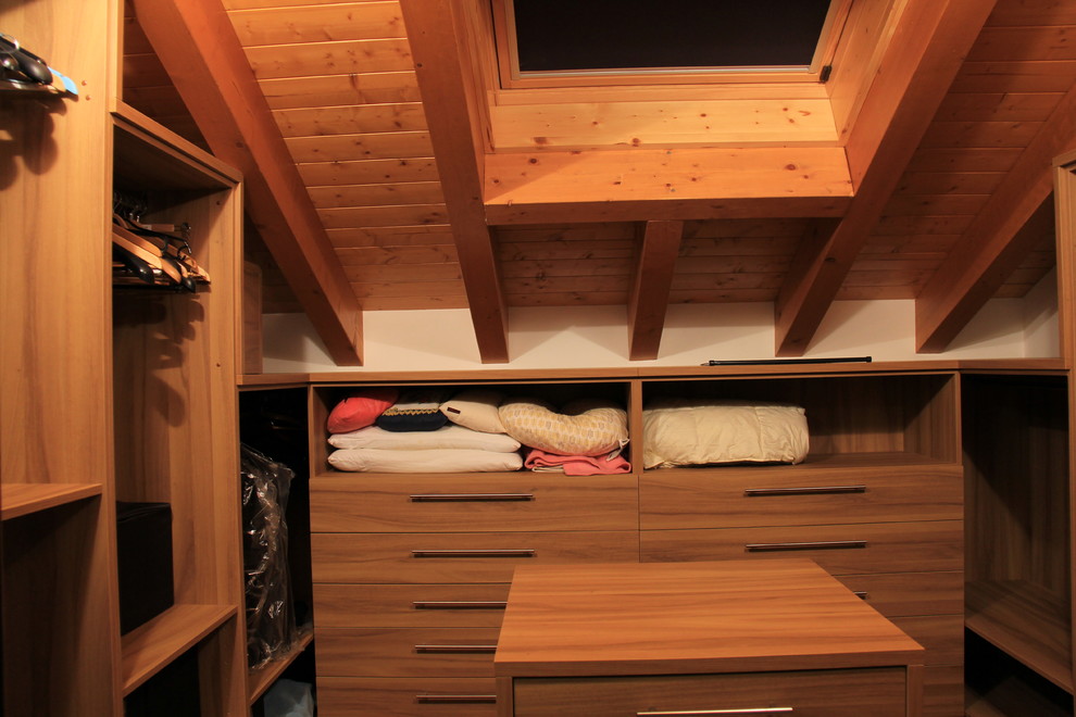 Esempio di una grande cabina armadio minimalista con nessun'anta, ante in legno chiaro e pavimento in legno massello medio