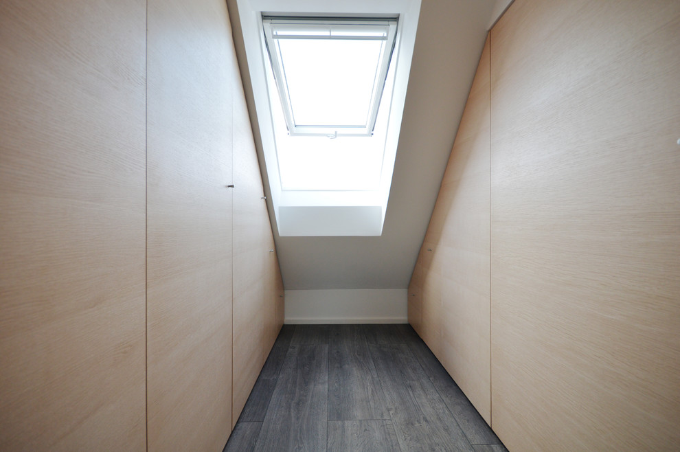 Пример оригинального дизайна: шкаф в нише среднего размера, унисекс в современном стиле с плоскими фасадами, светлыми деревянными фасадами, темным паркетным полом и серым полом