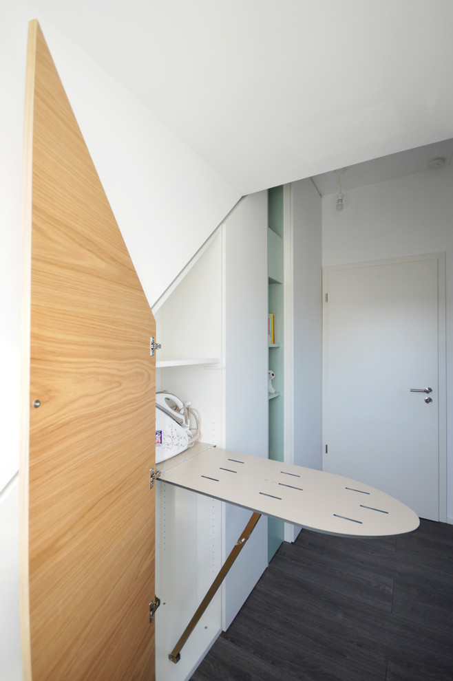 EIngebautes, Kleines, Neutrales Modernes Ankleidezimmer mit dunklem Holzboden, grauem Boden, flächenbündigen Schrankfronten und weißen Schränken in München