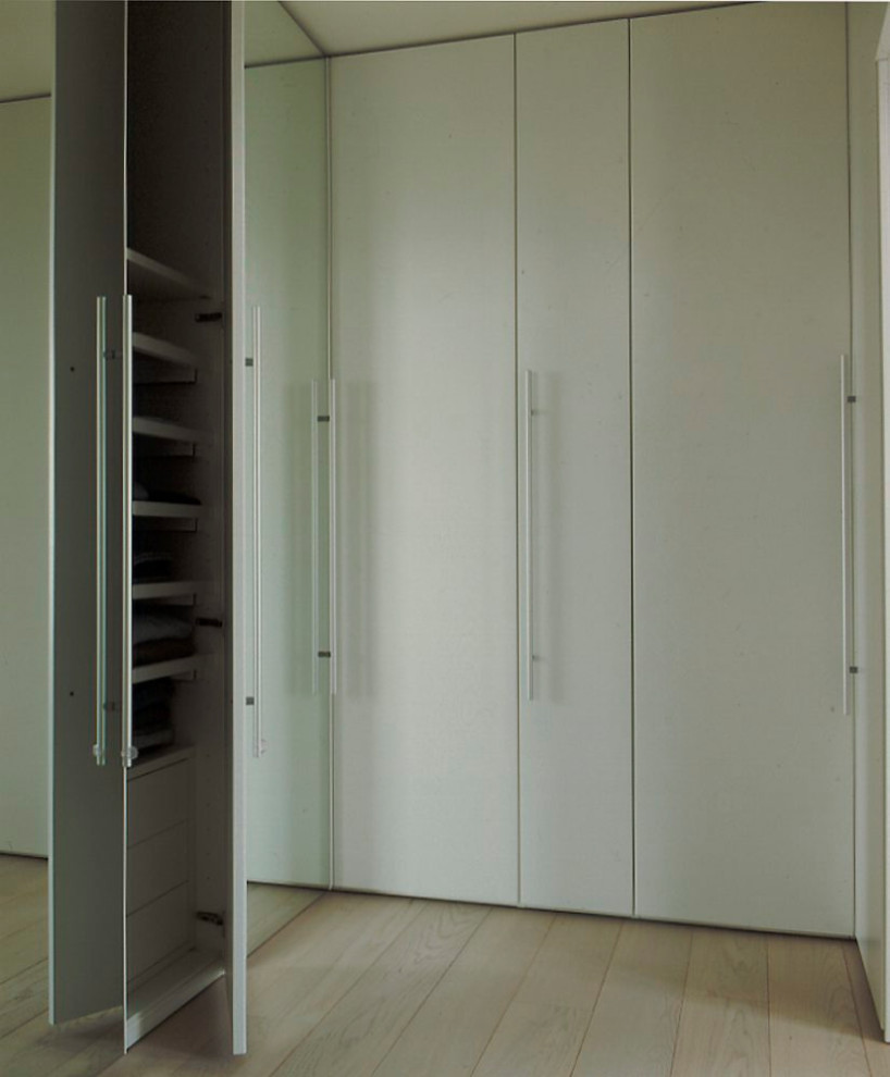 Foto di un'ampia cabina armadio unisex moderna con ante lisce, ante bianche, parquet chiaro e pavimento bianco