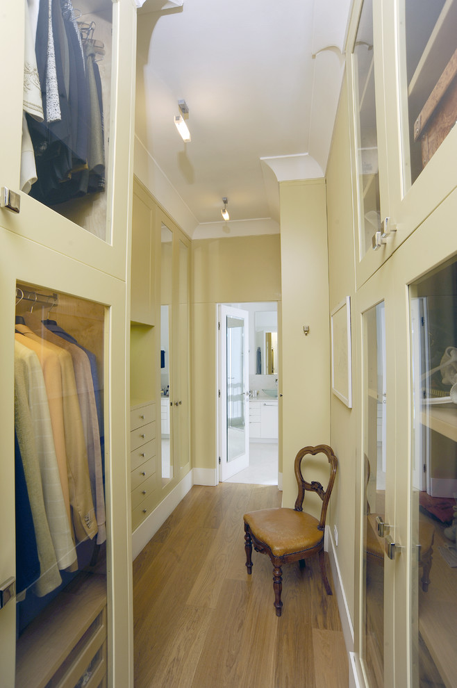 Foto de armario vestidor unisex actual de tamaño medio con armarios tipo vitrina, puertas de armario de madera clara y suelo de madera en tonos medios