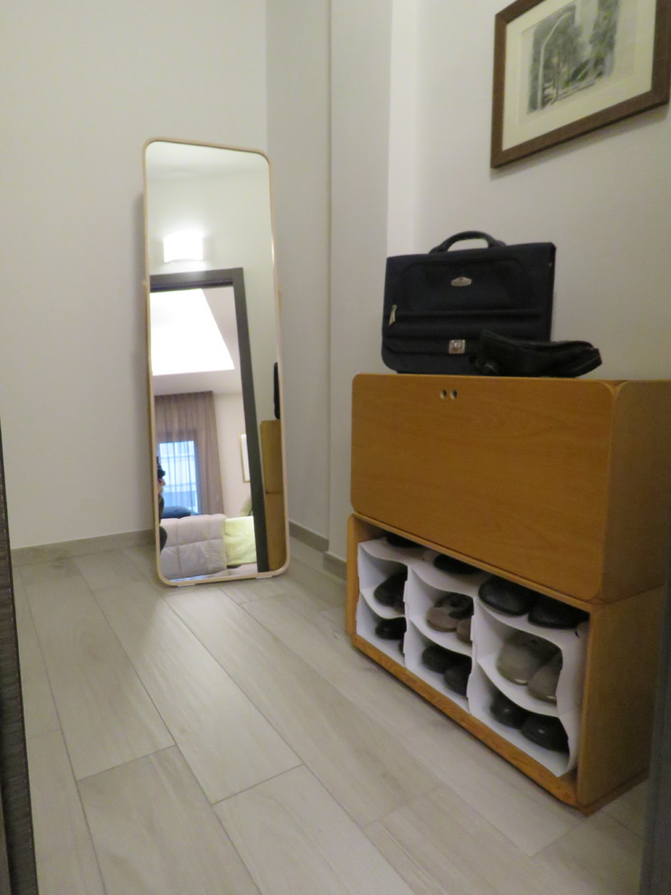 Ejemplo de armario vestidor de hombre minimalista pequeño con armarios abiertos, puertas de armario de madera clara, suelo de baldosas de porcelana y suelo beige