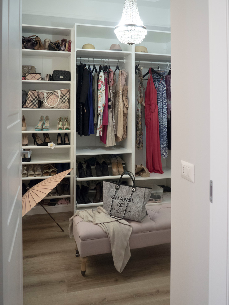 This is an example of a small eclectic walk-in wardrobe for women in Other with open cabinets and white cabinets.