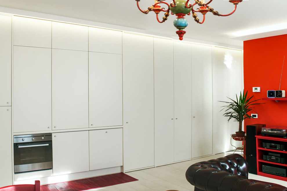 Imagen de armario unisex minimalista pequeño con puertas de armario blancas, suelo de madera clara y suelo blanco