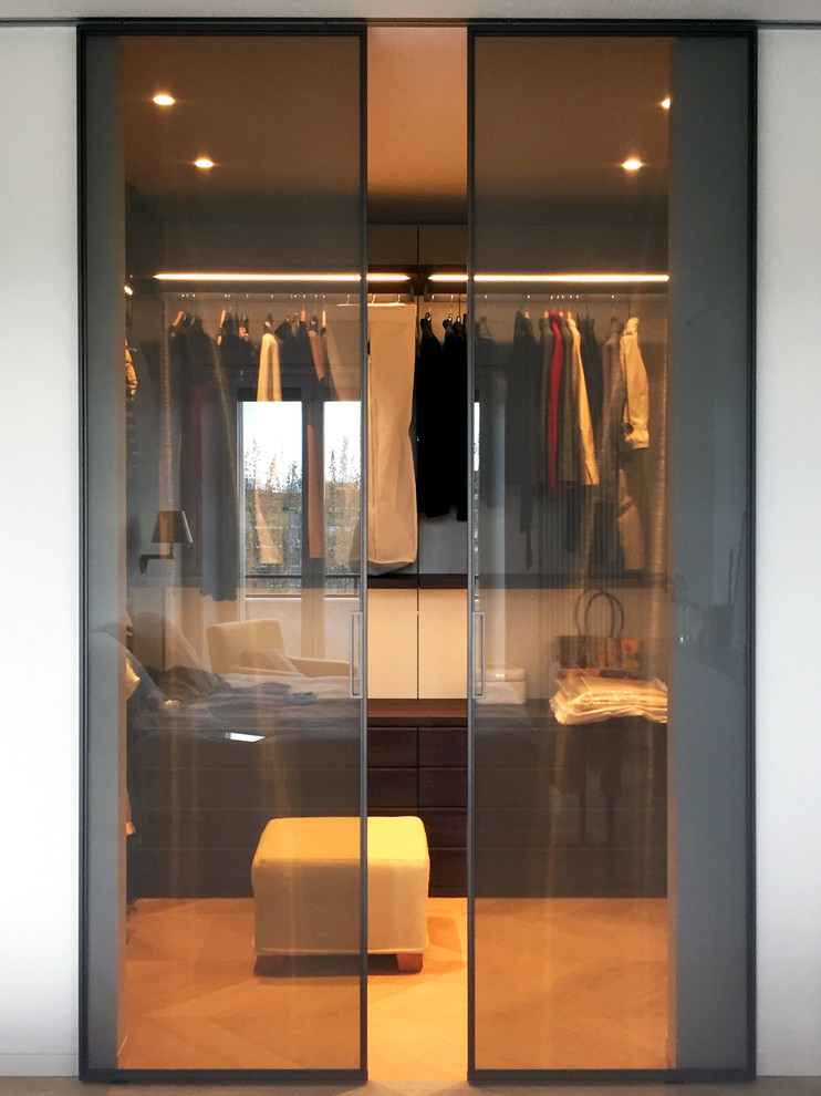 Imagen de armario vestidor de mujer moderno grande con armarios abiertos, puertas de armario de madera en tonos medios, suelo de madera en tonos medios y suelo beige