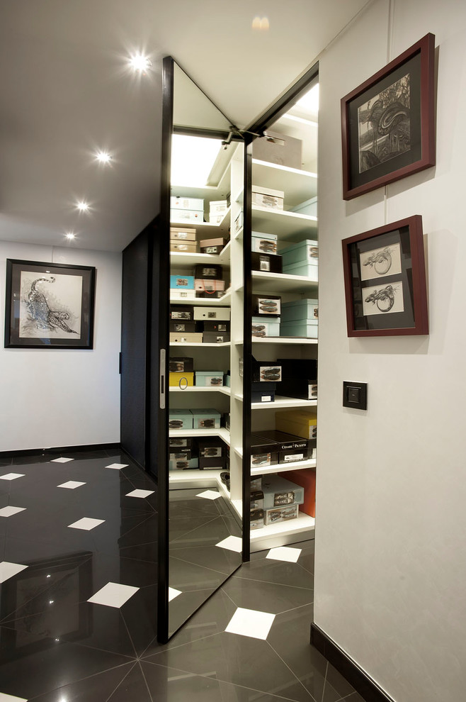 This is an example of a mid-sized eclectic women's walk-in wardrobe in Florence with glass-front cabinets, white cabinets, marble floors and black floor.
